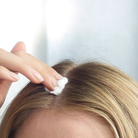Woman with hair loss applying Regaine®
